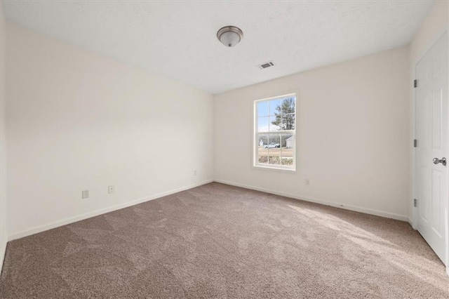 unfurnished room featuring visible vents, baseboards, and carpet flooring