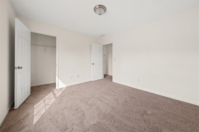 unfurnished bedroom featuring a closet, carpet flooring, and baseboards