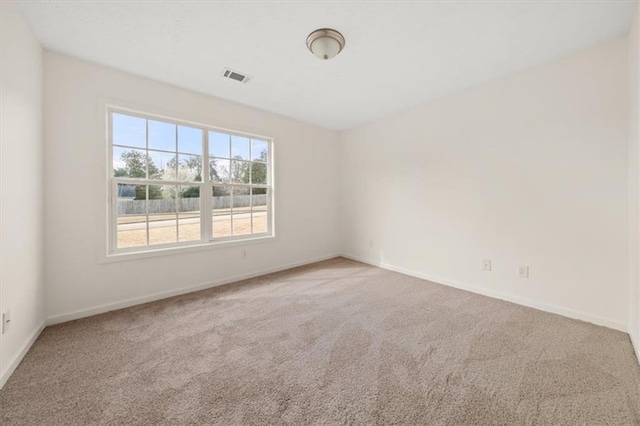 unfurnished room with visible vents, baseboards, and carpet flooring