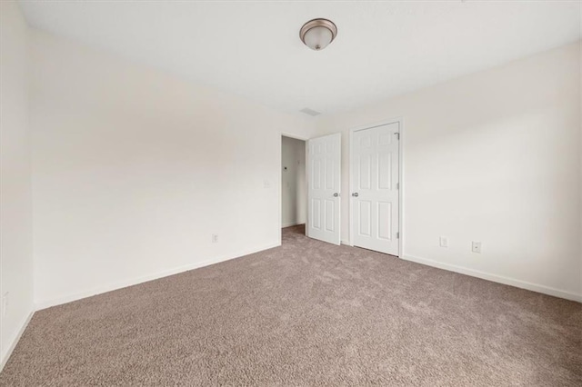 unfurnished room featuring carpet flooring and baseboards