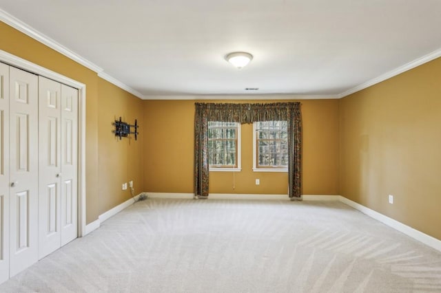 carpeted spare room featuring crown molding