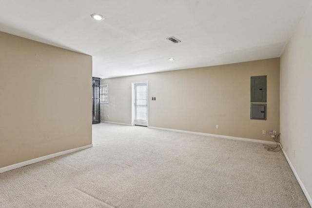 unfurnished room with light colored carpet and electric panel