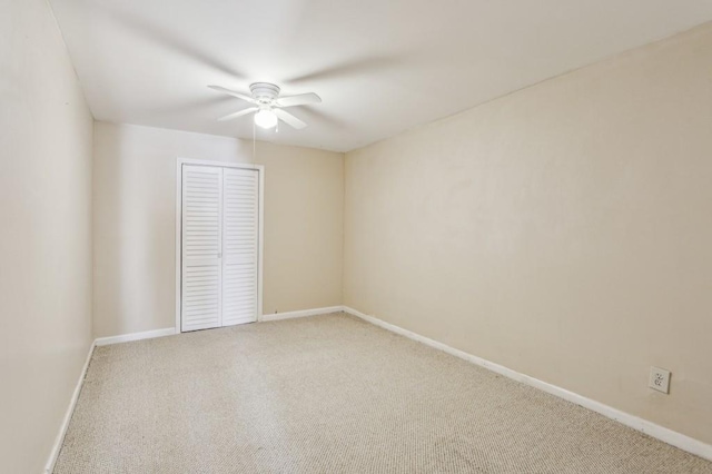 carpeted spare room featuring ceiling fan