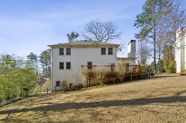 back of property featuring a wooden deck and a yard