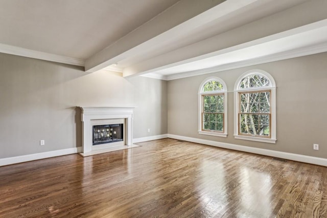 unfurnished living room featuring hardwood / wood-style flooring, ornamental molding, and beam ceiling