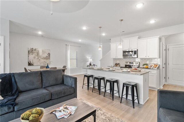 living room featuring light wood-type flooring and sink