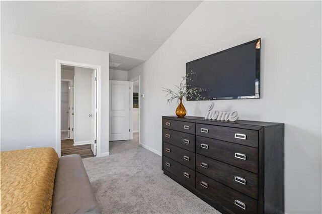 bedroom with light colored carpet and vaulted ceiling