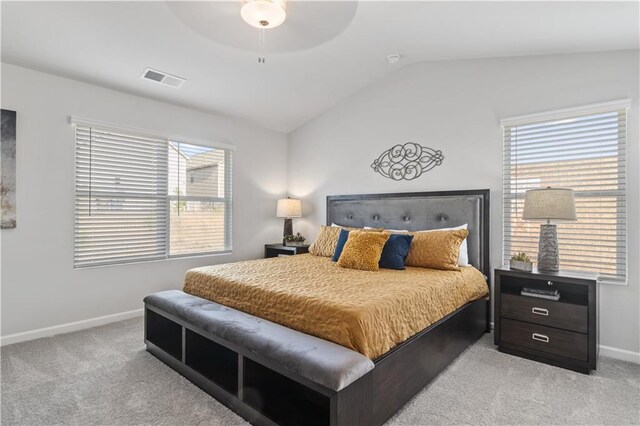 bedroom featuring ceiling fan, vaulted ceiling, light colored carpet, and multiple windows