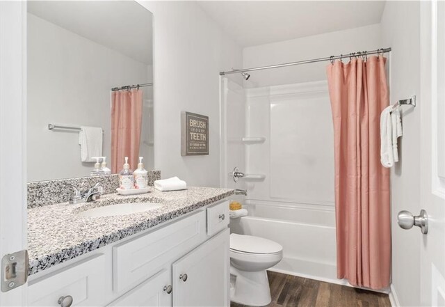 full bathroom with shower / bathtub combination with curtain, vanity, toilet, and wood-type flooring