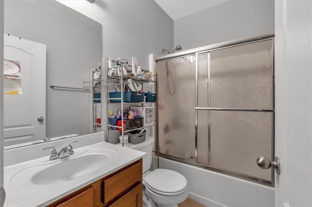 bathroom with vanity, enclosed tub / shower combo, and toilet