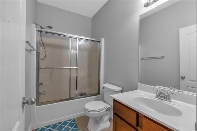 bathroom with tile patterned floors, vanity, combined bath / shower with glass door, and toilet