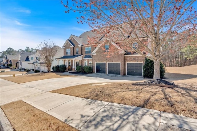 traditional home with a garage, driveway, brick siding, and a residential view
