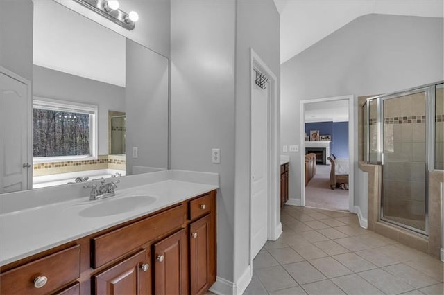 bathroom featuring vaulted ceiling, tile patterned flooring, a shower stall, connected bathroom, and a fireplace