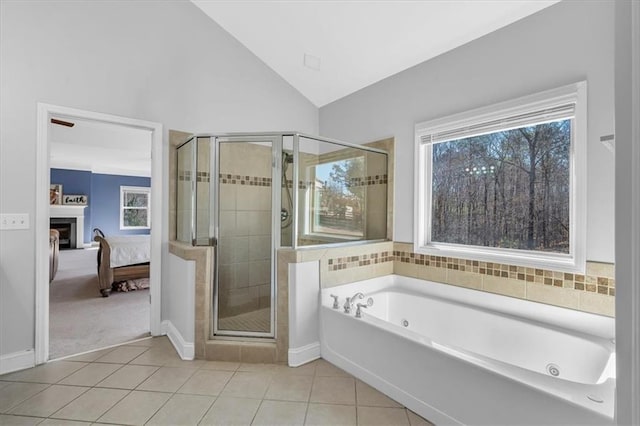 ensuite bathroom with tile patterned flooring, a stall shower, a whirlpool tub, vaulted ceiling, and baseboards