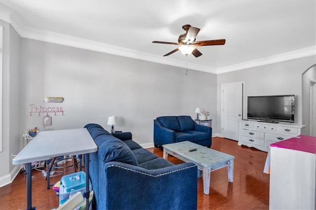 living room with a ceiling fan, ornamental molding, baseboards, and wood finished floors