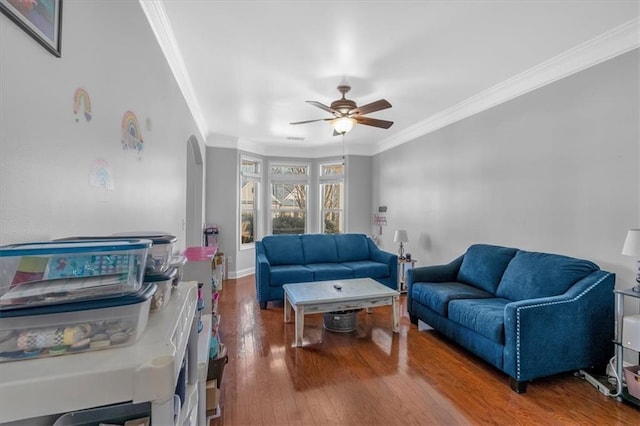 living room with arched walkways, crown molding, ceiling fan, and wood finished floors