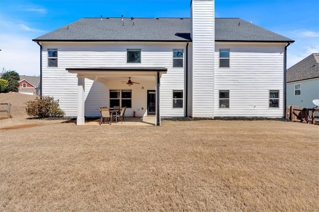 back of property with a ceiling fan, a chimney, a patio, and roof with shingles