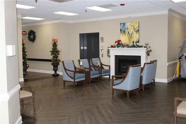 interior space with dark parquet flooring, a paneled ceiling, elevator, and ornamental molding