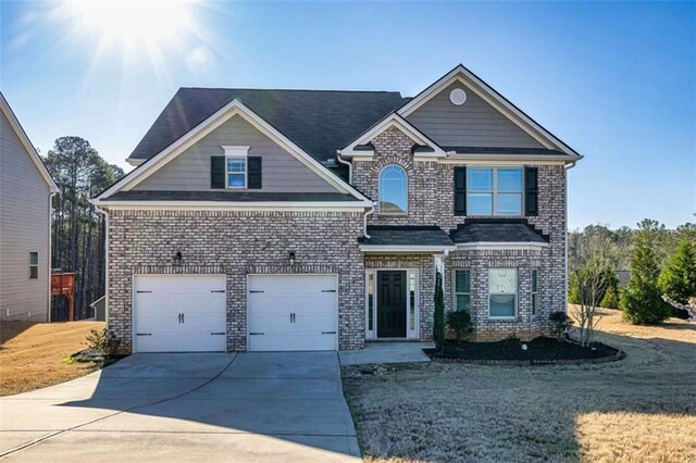 view of front facade with a front yard, driveway, an attached garage, and brick siding