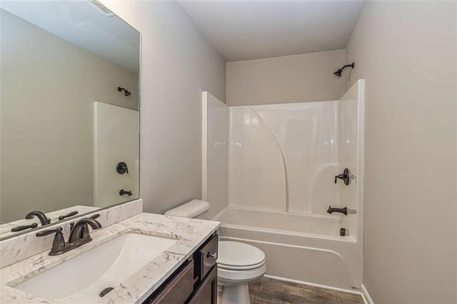full bathroom featuring toilet, vanity, washtub / shower combination, and wood finished floors