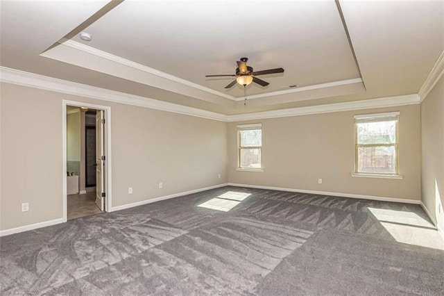 carpeted empty room featuring a raised ceiling, a ceiling fan, and ornamental molding