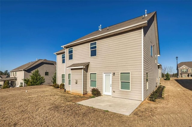 rear view of house featuring a patio and a lawn