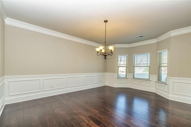 unfurnished room with visible vents, a wainscoted wall, wood-type flooring, ornamental molding, and a notable chandelier