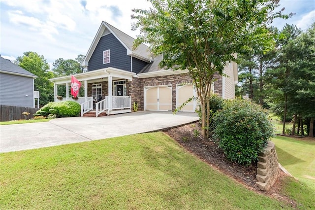 view of front facade featuring stone siding, a front yard, a porch, and driveway