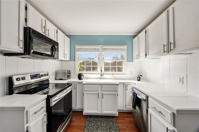 kitchen featuring sink, crown molding, dark wood-type flooring, stainless steel range with electric stovetop, and white cabinets