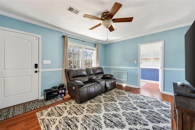 living room with ceiling fan, ornamental molding, and hardwood / wood-style floors