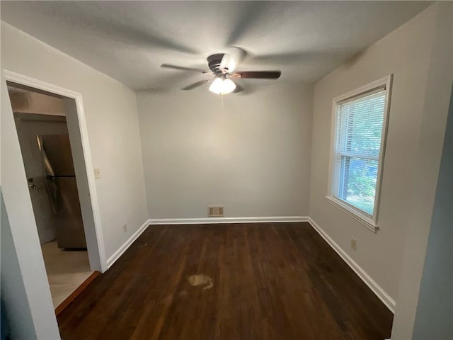 empty room with dark hardwood / wood-style floors and ceiling fan