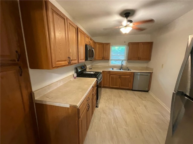 kitchen featuring stainless steel appliances, ceiling fan, and sink