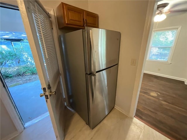 kitchen with light tile patterned floors, stainless steel refrigerator, and ceiling fan