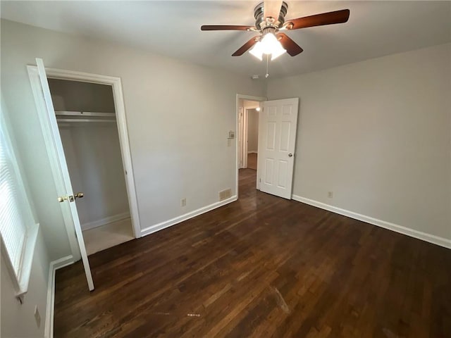 unfurnished bedroom with ceiling fan, a closet, and dark hardwood / wood-style floors