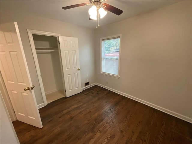 unfurnished bedroom with a closet, ceiling fan, and dark wood-type flooring