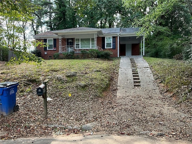 ranch-style house with covered porch and a carport