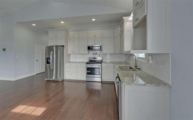 kitchen featuring dark wood-type flooring, sink, light stone counters, stainless steel appliances, and white cabinets