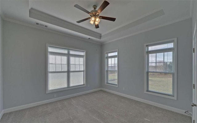 carpeted empty room featuring crown molding, ceiling fan, and a tray ceiling