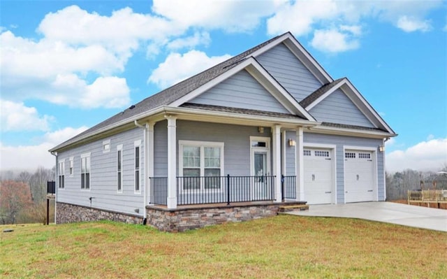 view of front of property featuring a porch, a garage, and a front yard