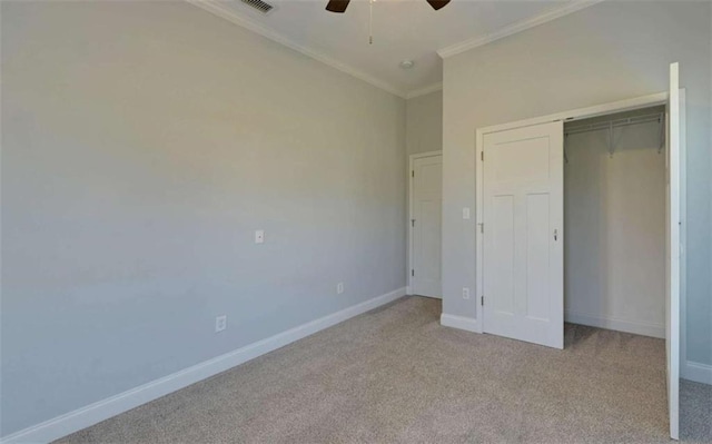 unfurnished bedroom featuring crown molding, light colored carpet, ceiling fan, and a closet