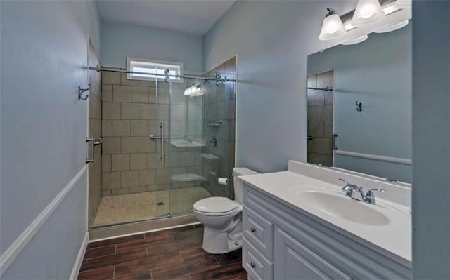 bathroom with vanity, toilet, and a shower with shower door