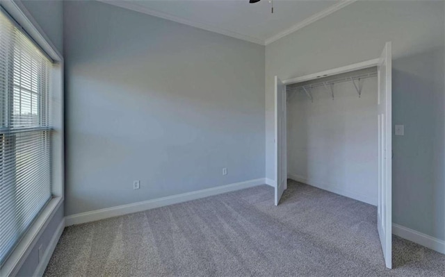 unfurnished bedroom featuring crown molding, carpet flooring, ceiling fan, and a closet