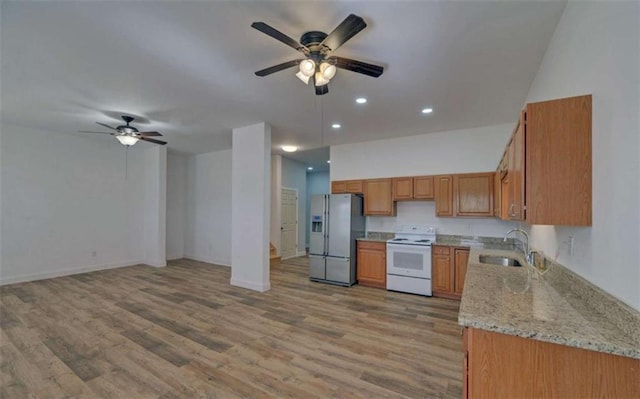 kitchen with sink, white electric range oven, stainless steel refrigerator with ice dispenser, light stone countertops, and light hardwood / wood-style flooring