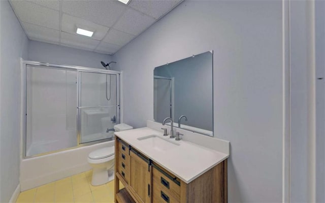 full bathroom with toilet, a paneled ceiling, vanity, and bath / shower combo with glass door