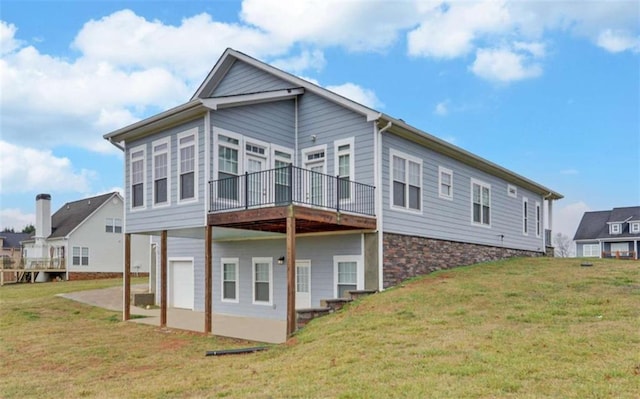 back of house with a wooden deck, a patio area, and a lawn