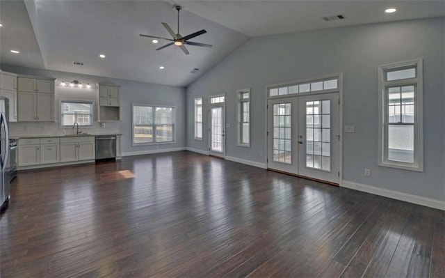 unfurnished living room with french doors, dark wood-type flooring, sink, and a wealth of natural light