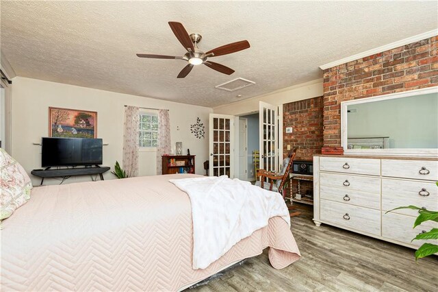 255 Shipp Cir, Hiram, GA 30141 - bedroom with wood finished floors, attic access, brick wall, a textured ceiling, and ceiling fan