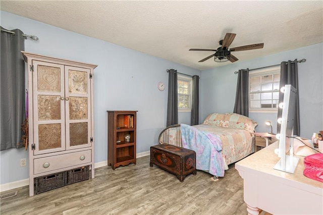 255 Shipp Cir, Hiram, GA 30141 - bedroom with light wood finished floors, multiple windows, a textured ceiling, a ceiling fan, and baseboards