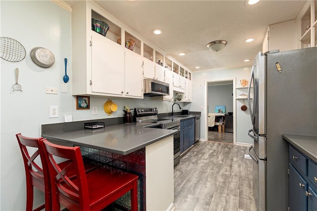 255 Shipp Cir, Hiram, GA 30141 - kitchen featuring appliances with stainless steel finishes, a sink, white cabinetry, a peninsula, and light wood-style floors