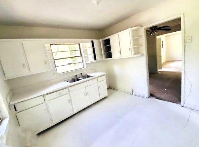 kitchen with open shelves, a sink, concrete floors, white cabinets, and ceiling fan